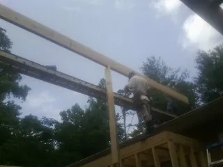 Carpenter setting a ridge beam over a new addition frame — Ice Dam Removal by Roofing Brothers in Rochelle