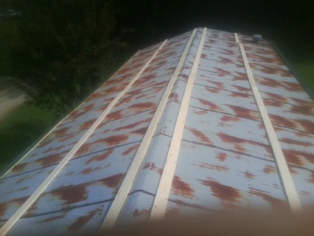 Rusted metal roof panels with new wood purlins before replacement — Storm Damage Roof Repair in Rochelle by Roofing Brothers