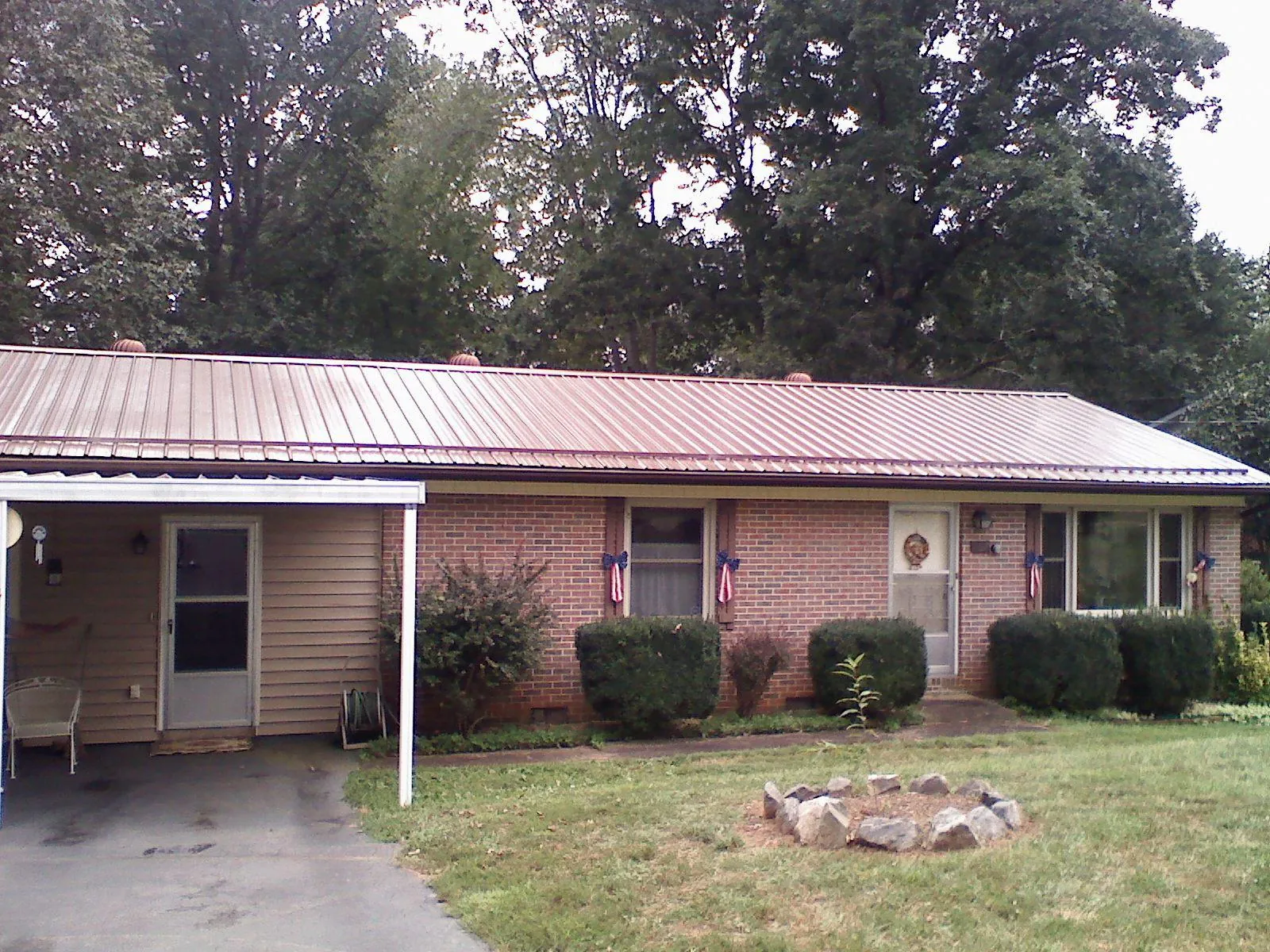 Bronze metal roof and carport on a brick ranch home — Roof Repair work by our crew in Rochelle